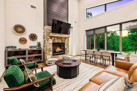 Cozy up by the fireplace in this stylish living room, complete with breathtaking views of the outdoors