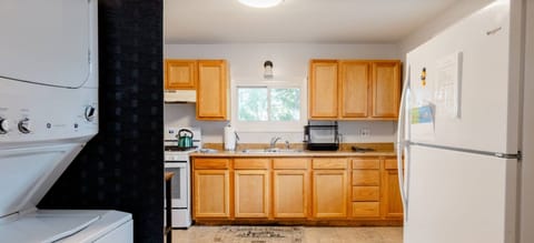 Entering the kitchen is the refrigerator and washer dryer left. 