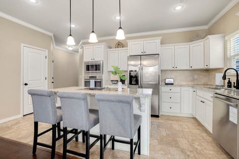 The granite island and three barstools sit in the center of this space.