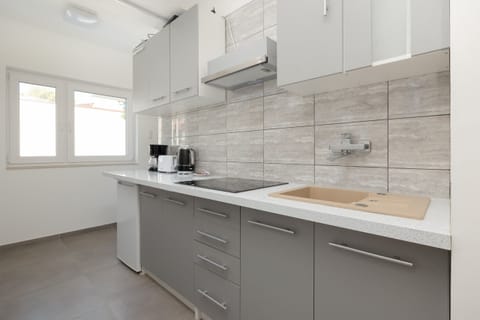 A sleek kitchen with white cabinets, a tiled backsplash, and modern appliances for a convenient stay.
