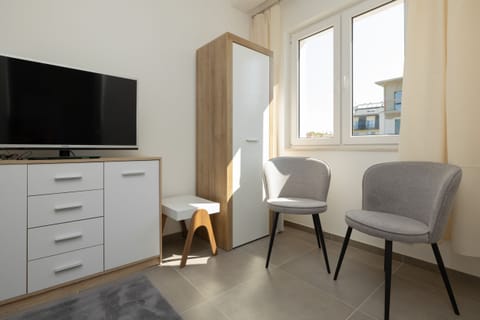 A modern seating area with chairs and a table, situated near a large window.
