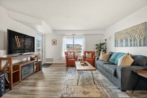 Living room with an electric fireplace, TV, walkout access to the private second-floor balcony and cozy seating options with a queen sleeper sofa (linens included.)