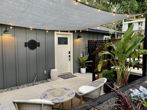 Shade sail + bistro lights, with patio seats at your own private space