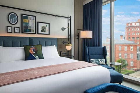 Sink into crisp linens beside bright, skyline-facing windows.