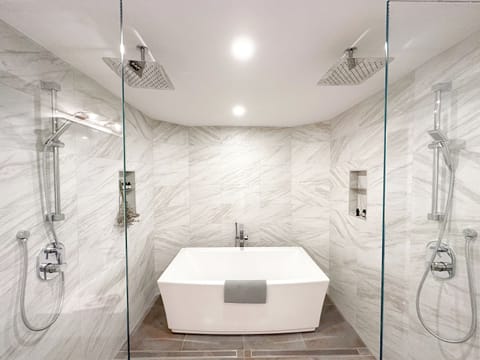 Unwind in your luxurious marble sanctuary with dual rainfall showers and a soaking tub for ultimate relaxation.