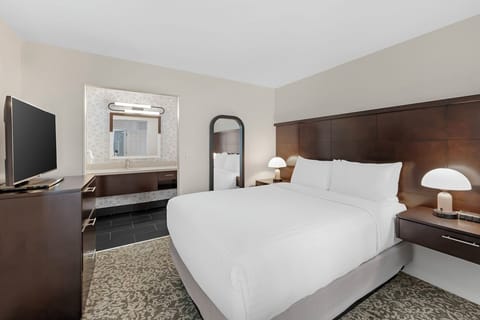 Unwind on crisp linens with convenient TV and vanity.