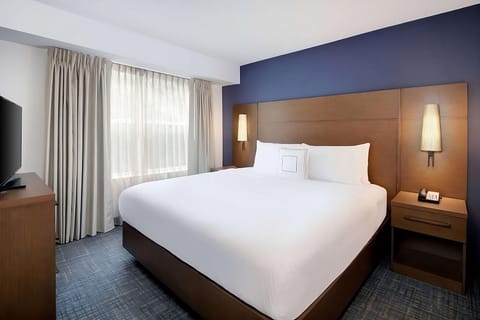 Unwind in crisp linens and a serene, modern king bed.