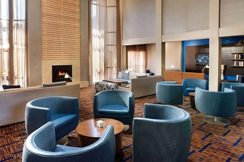 Unwind by the fireplace in a sunlit, stylish lounge.