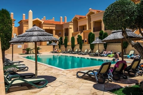 Unwind poolside on sun loungers under breezy thatched umbrellas.