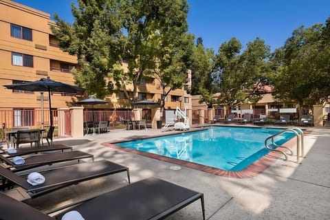 Dive into sunlit relaxation with sparkling pool and loungers.
