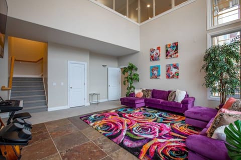 Spacious lower level living area with modern furniture and vibrant accents