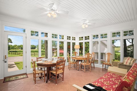 Views! Sunroom has seating for 9 at 2 tables and also has a vintage glider sofa.