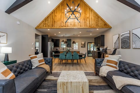 Luxury cabin decor with leather sofas, open floorplan, with gorgeous wood beams and vaulted ceiling