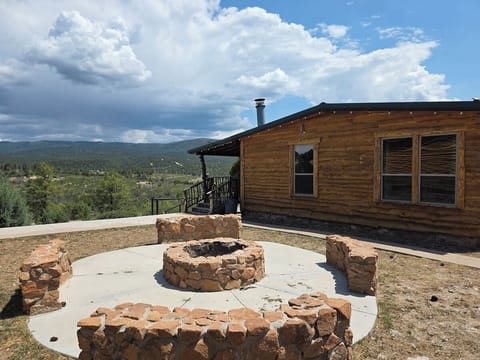 Cabin exterior with the shared stone fire pit just below the deck.