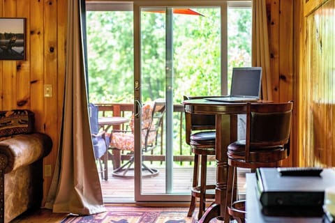 View of tall table & bar stools right in front of one of the sliding glass door in the living room for those needing to possibly catch up on work or just eat a snack or enjoy your favorite beverage!