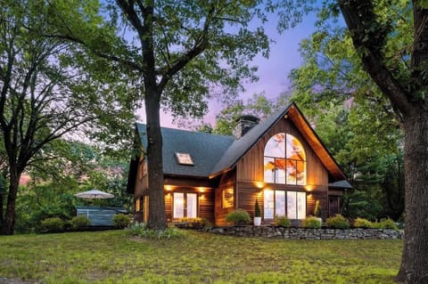 The house aglow at dusk, surrounded by 8 scenic acres

