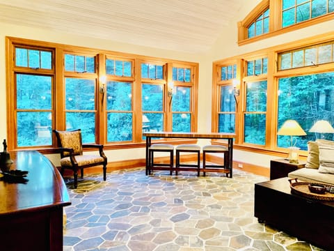Tavern room with sleeper sofa, radiant flooring, 80” TV & bar table.