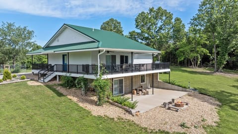 Two-level custom home with wraparound deck, covered patio, and fire pit.