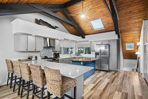 Gather at the breakfast bar overlooking the Chef's kitchen with large gas range, stainless-steal appliances and plenty of skylight counters.