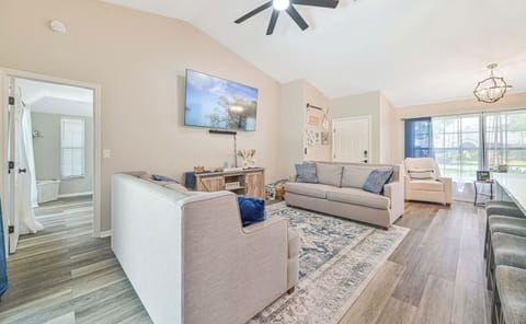 Beautiful living area with high ceilings, comfortable seating, large TV