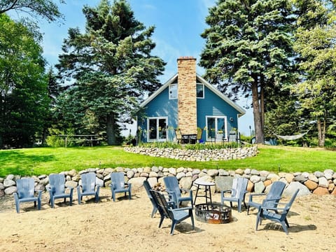 The house features a sand beach, fire pit, and cement patio over-looking Huron