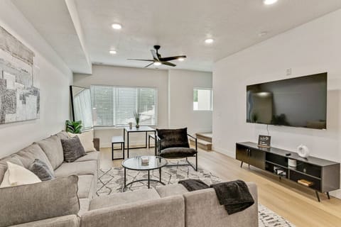Relax in the modern living room featuring a plush sectional, smart TV, and natural light for the perfect gathering spot 📺🛋️☀️