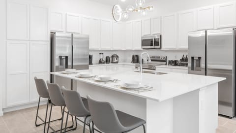 Sip on your favorite cocktails at our stylish kitchen bar, offering you a delightful way to unwind and relax.