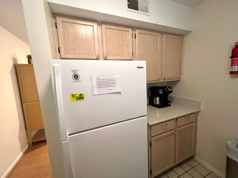 The kitchen nook features a full-size refrigerator, coffee station, and ample cabinet space for storage.