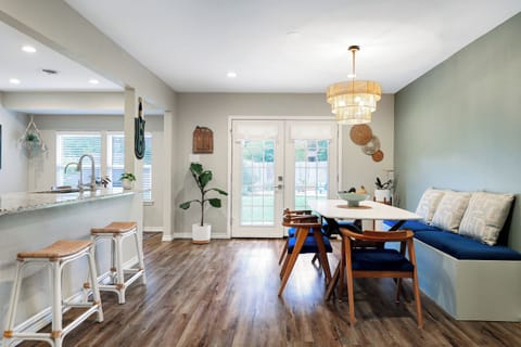Open dining with table for 6, 2 bar stools & vibrant live plants throughout.