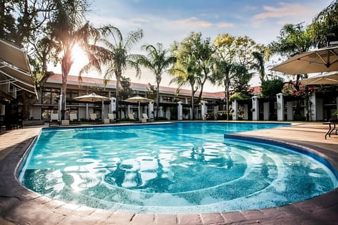 Dive into a resort-style pool framed by swaying palms.