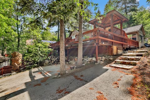 Welcoming cabin entry surrounded by towering pine trees, offering fresh mountain air and a peaceful forest setting—the perfect first impression for your Big Bear Lake getaway.