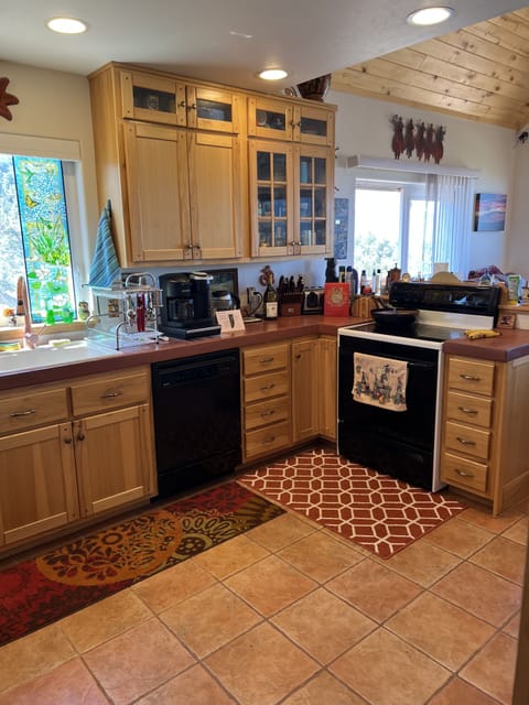 Kitchen with KitchenAide coffee grinder, and complimentary k-cups, ground & bean