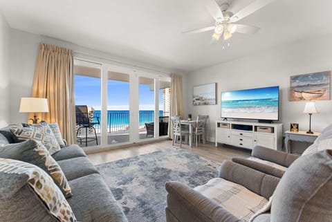 Relax in the cozy living area with a large smart TV and floor-to-ceiling windows showcasing stunning ocean views.