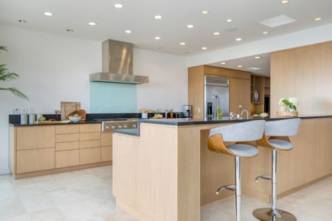 Fully-equipped kitchen with modern appliances and barstool seating at the island counter.