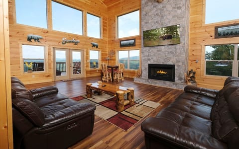 Spacious living room with large windows, cozy fireplace, and mountain views.
