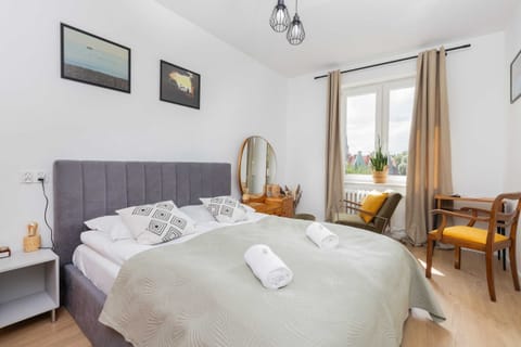 A bright bedroom featuring a comfortable double bed with fresh linens and natural light streaming through the window.