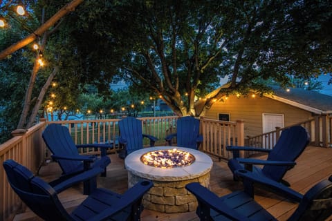 Cozy fire pit deck with string lights and Adirondack seating