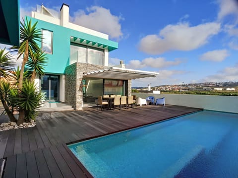 Backside of the house: pool, deck, dinner table, lounge area