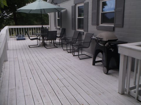 Deck with seating, grill and cornhole boards.