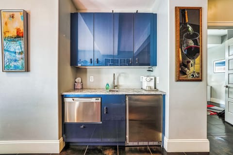 Living room wet bar with sink, espresso maker, fridge, ice maker, dishwasher.