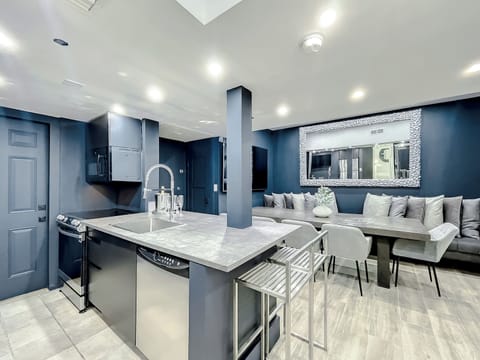 Full-size kitchen with brand new state-of-art Samsung stove, convection oven, air fryer, island bar with in-kitchen dining, entertaining 70-inch smart TV in the dining room, 50-inch in kitchen, stone dining table for up to 12 persons & bar seating.