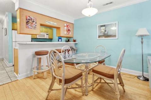 Dining area with round table, chairs, and ocean-inspired wall art