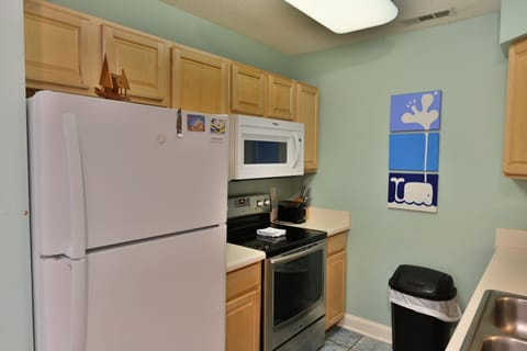 Full kitchen with white appliances and upper cabinets