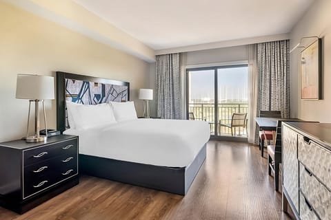 Unwind in a sunlit king room with breezy balcony views.