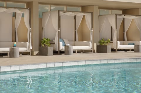 Unwind in shaded cabanas with cool drinks by the water.