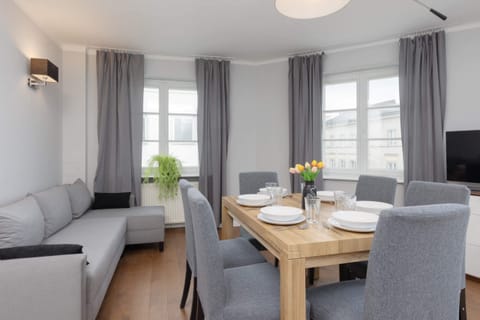 A combined dining and living area, featuring stylish gray chairs and tasteful decor.