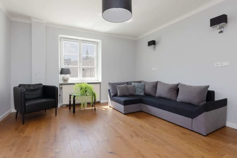 A spacious living area featuring a comfortable gray sofa, coffee table, and ample natural light, ideal for relaxation and socializing.