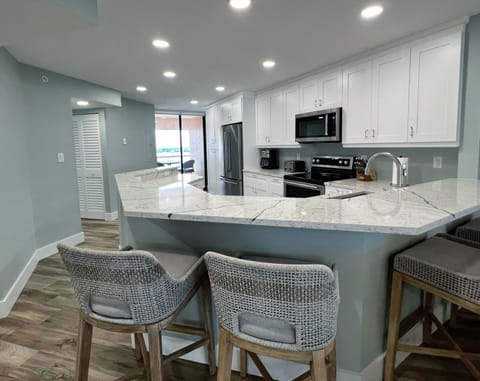 Bar stool seating off the open kitchen and a view of the interco - Bar stool seating off the open kitchen and a view of the intercoastal from this side, plus a beach view from the other angle.