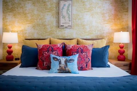 Sleep like you're on an easy cruise down the Mississippi River in this themed room with colorful pillows and charming wallpaper.
