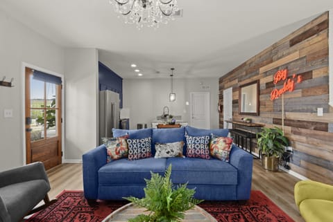 The hand crafted and stained pine door lead into the authentic living area with touches of natural wood, colorful plants and deep red Big Daddy’s sign.